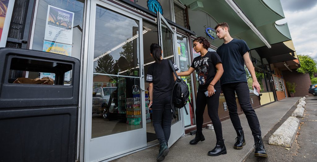 Grupo de adolescentes que entra a una tienda de conveniencia